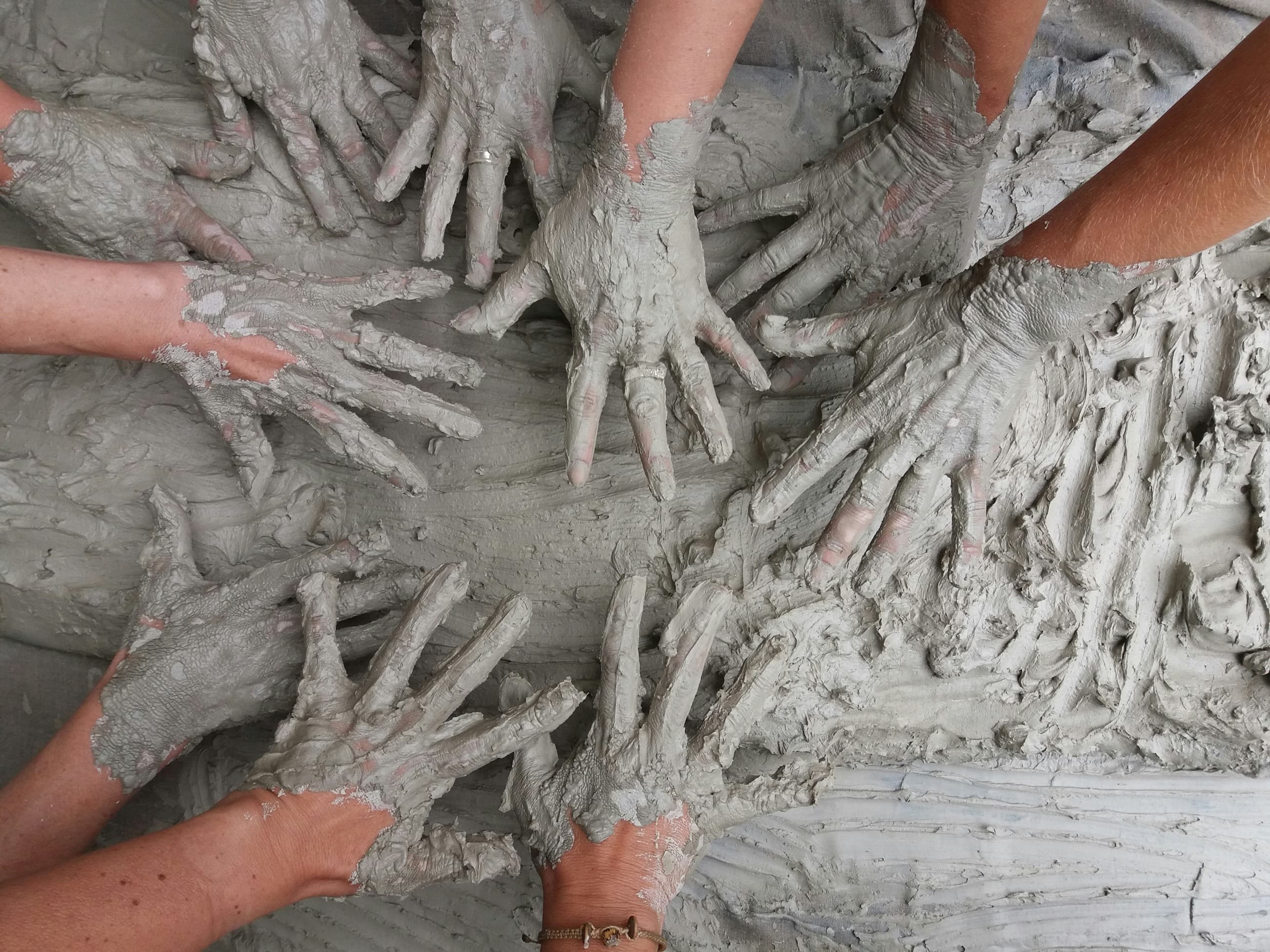 Hands shaping clay in a hand-building pottery class
